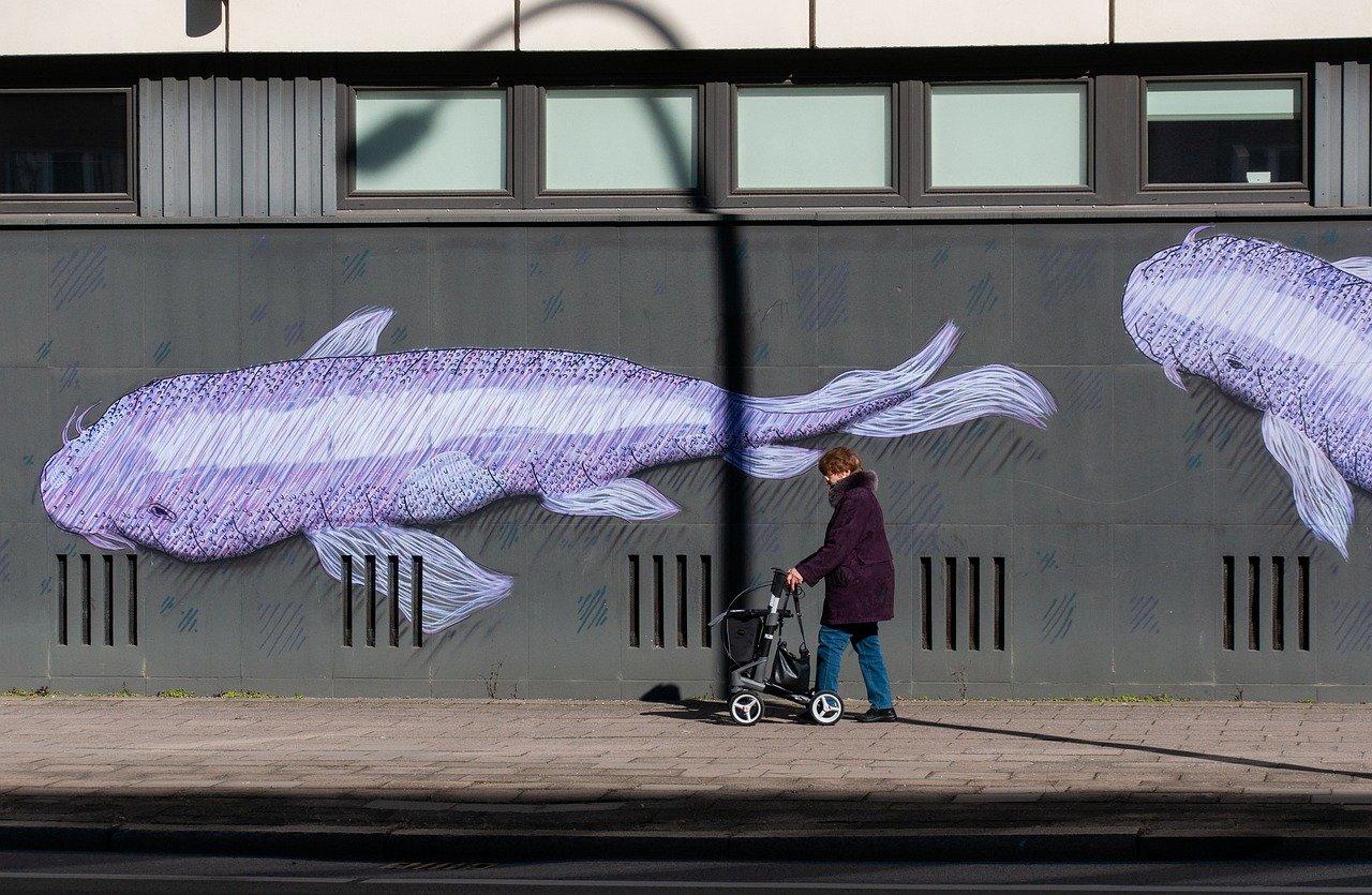 אישה מבוגרת ברחוב עם גרפיטי