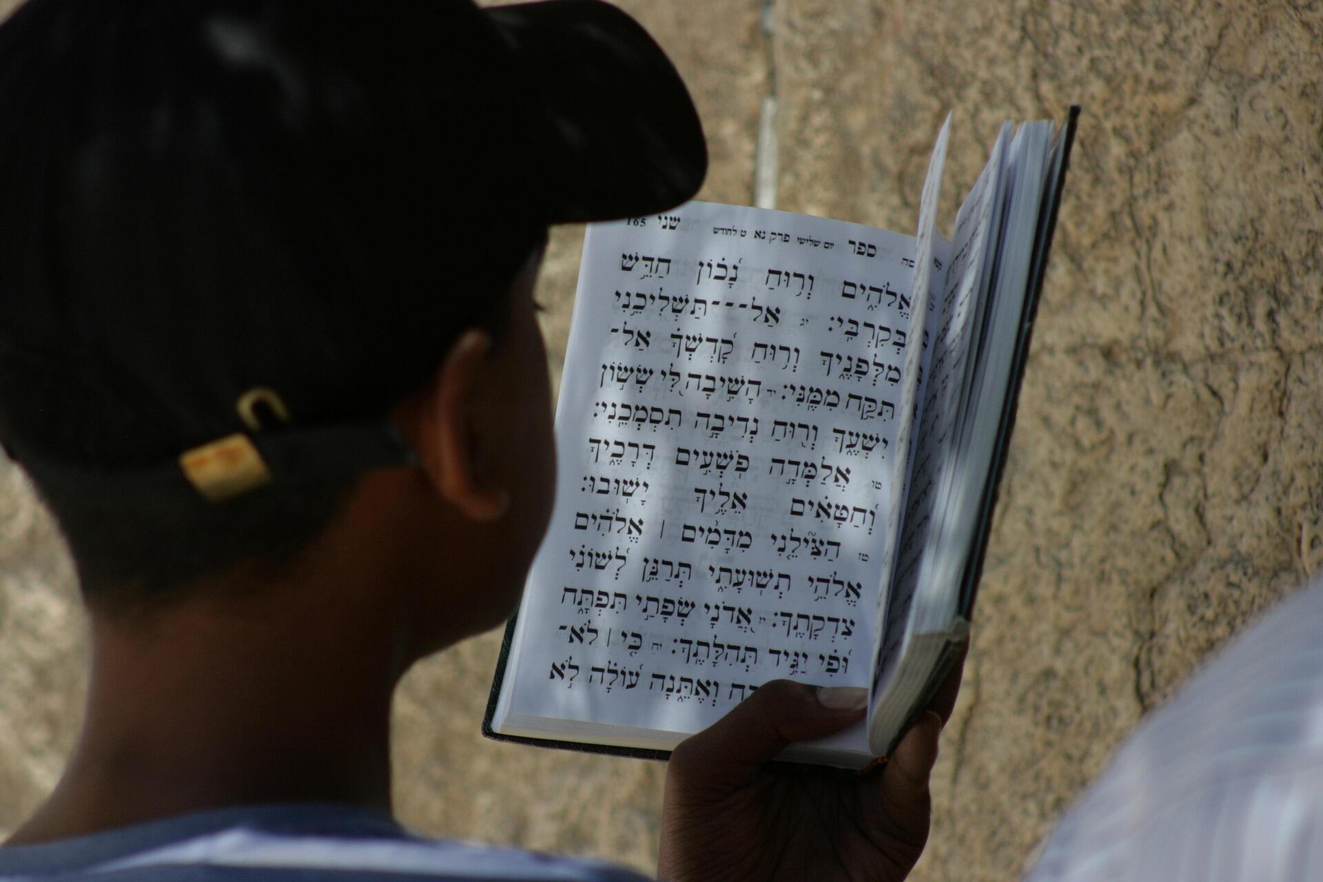 אדם קורא בספר תפילה