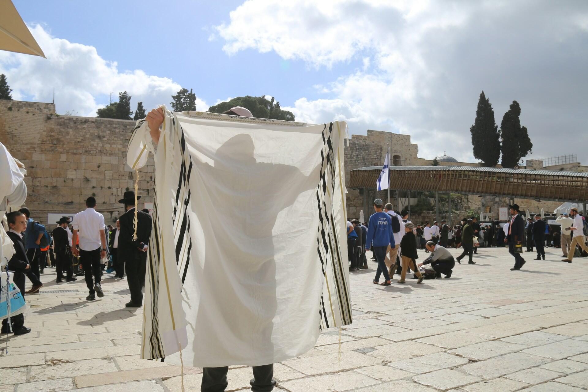 גבר מתעטף בטלית בכותל