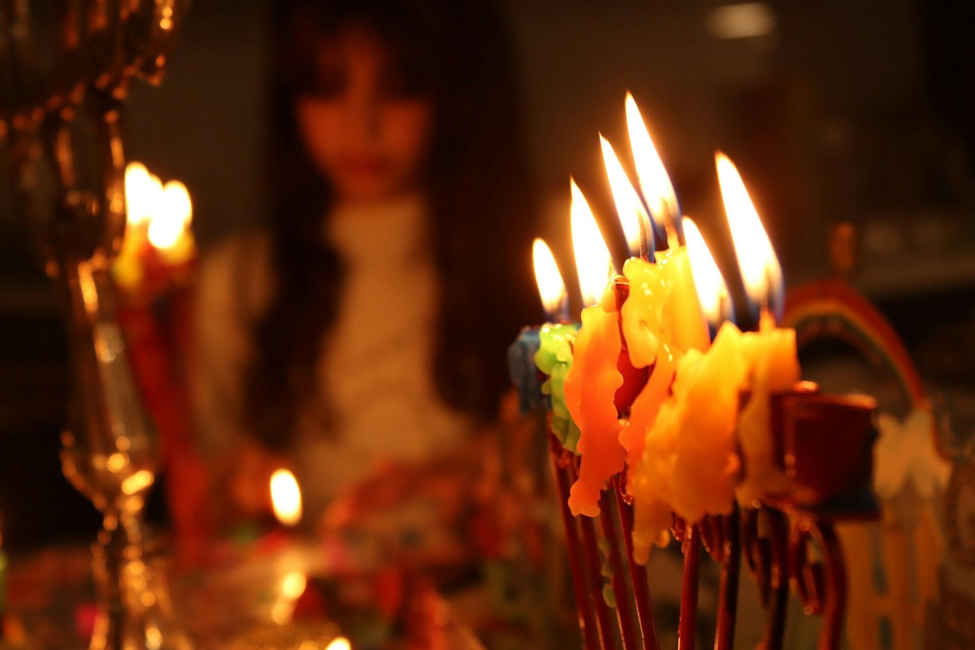 ילדה מול חנוכייה בוערת