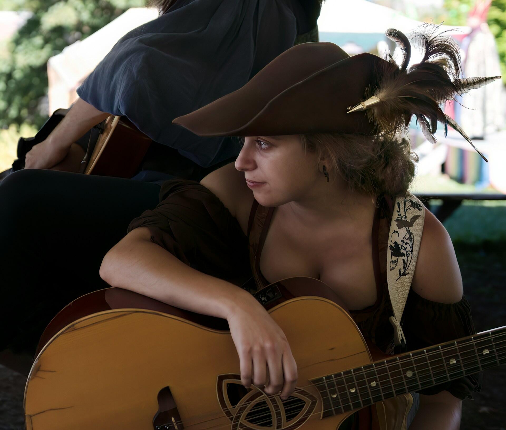 אישה בתחפושת רנסאנס מנגנת על גיטרה