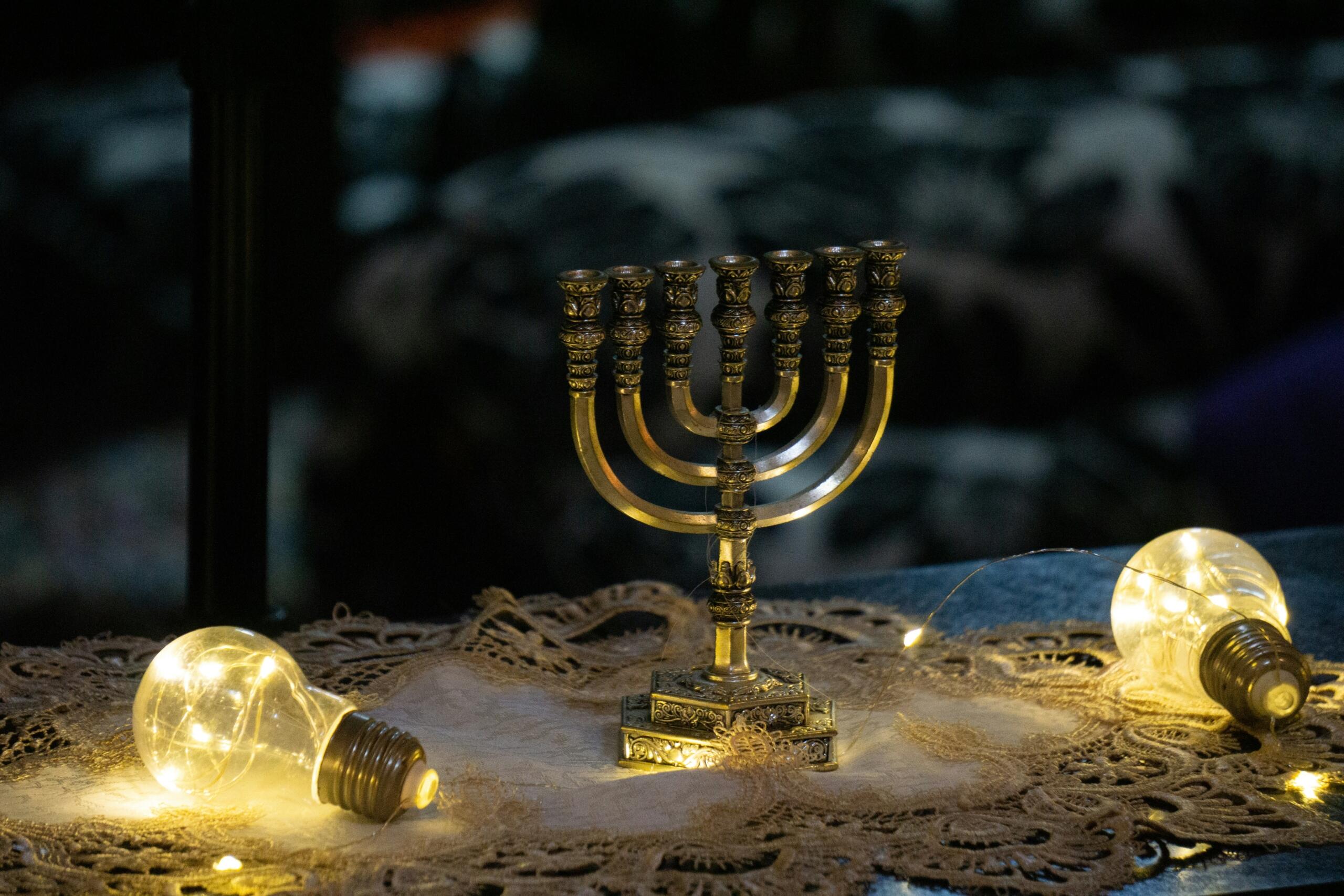 מנורה קטנה ניצבת על שולחן לצד 2 נורות צהובות מוארות על רקע שחור