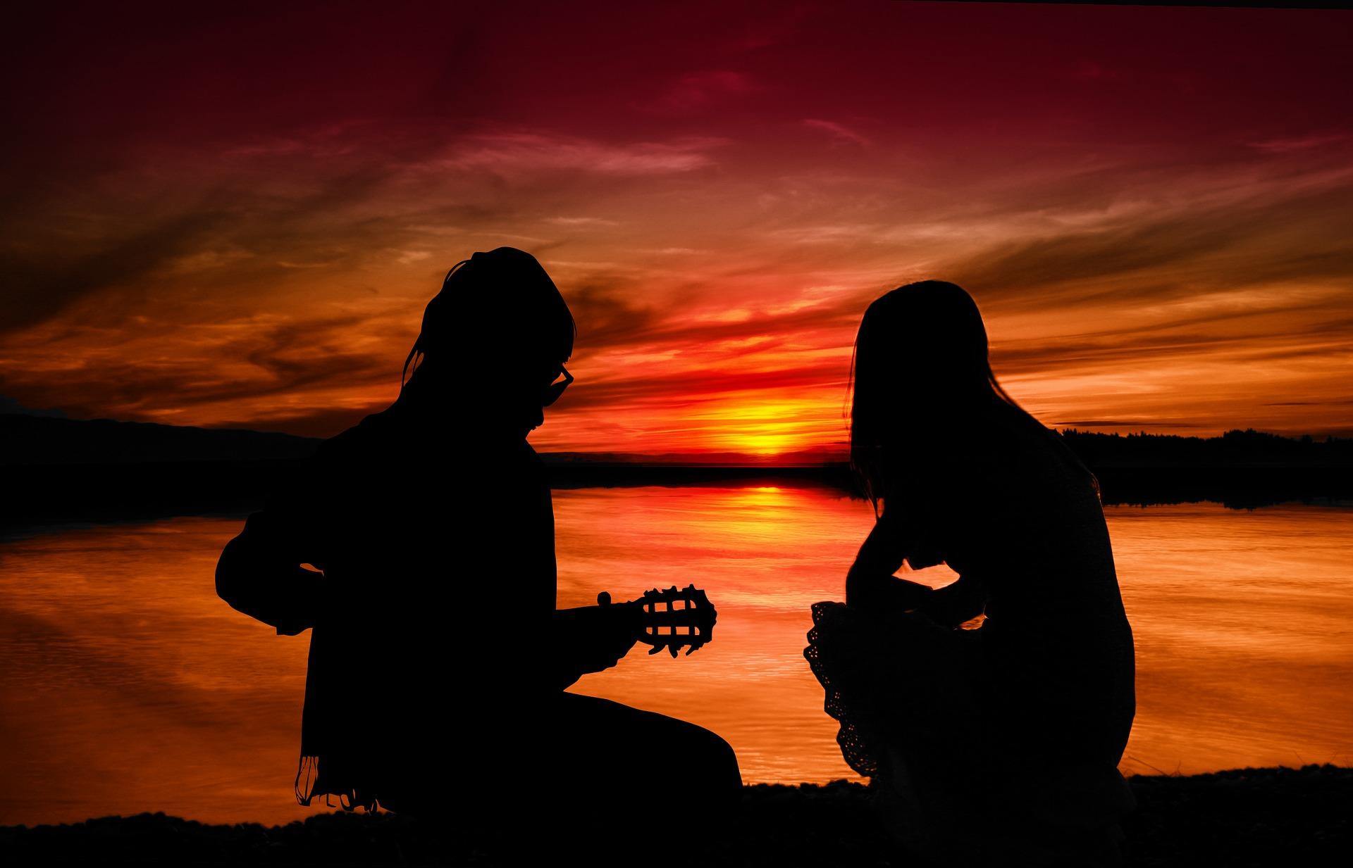 guitarist with companion in sunset