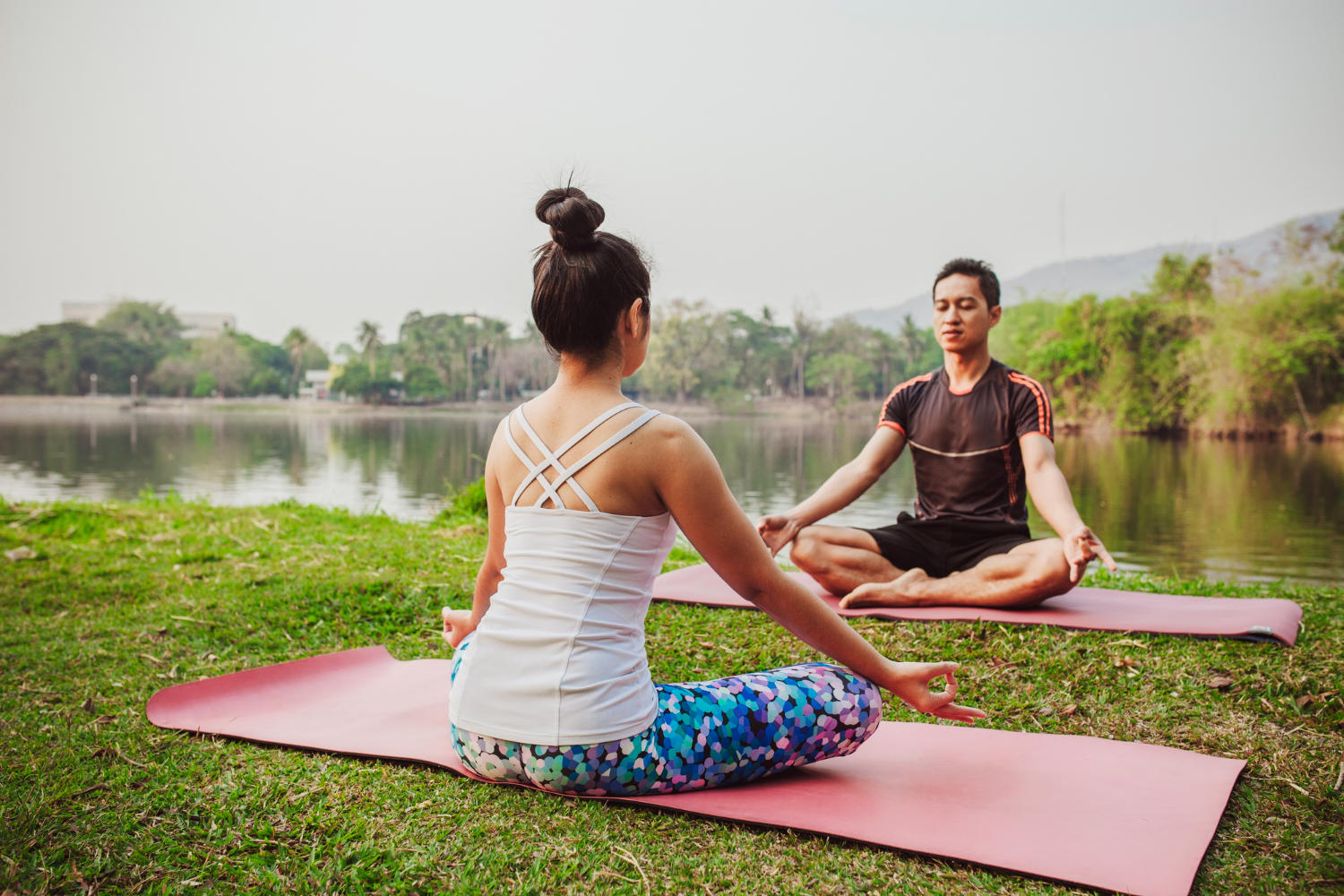A yoga teacher and student outdoors