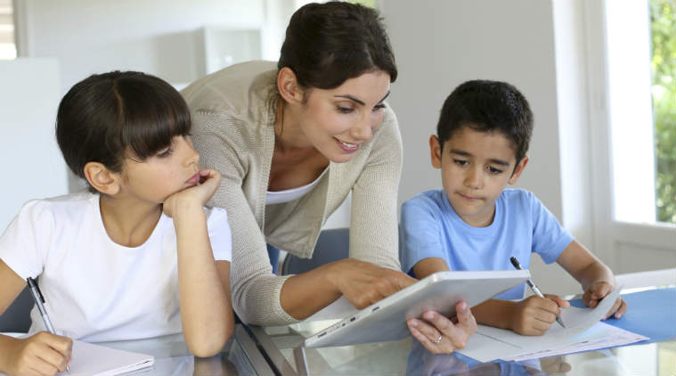 A teacher assisting children with their lessons