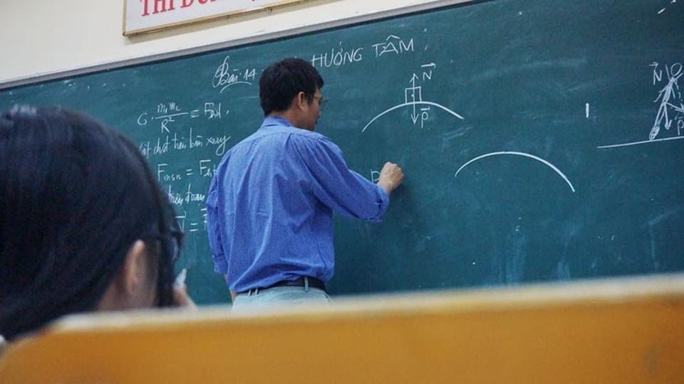 A teacher solving physics problems.