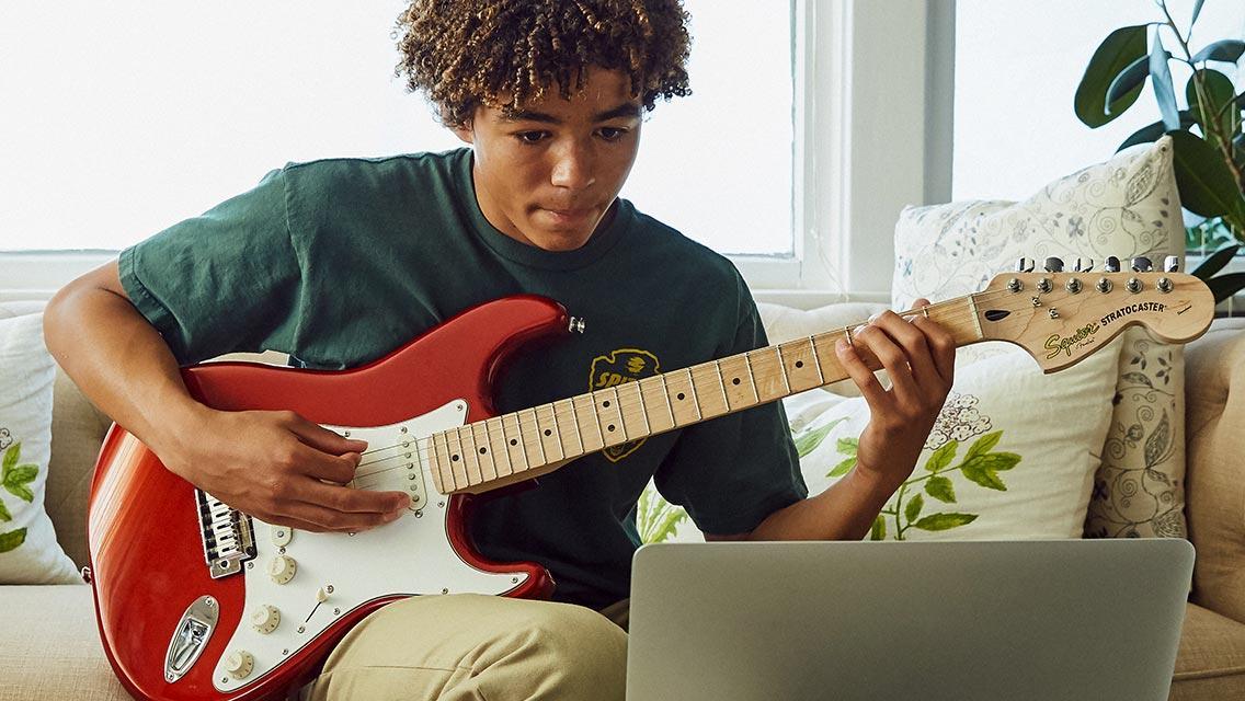 A student learning guitar