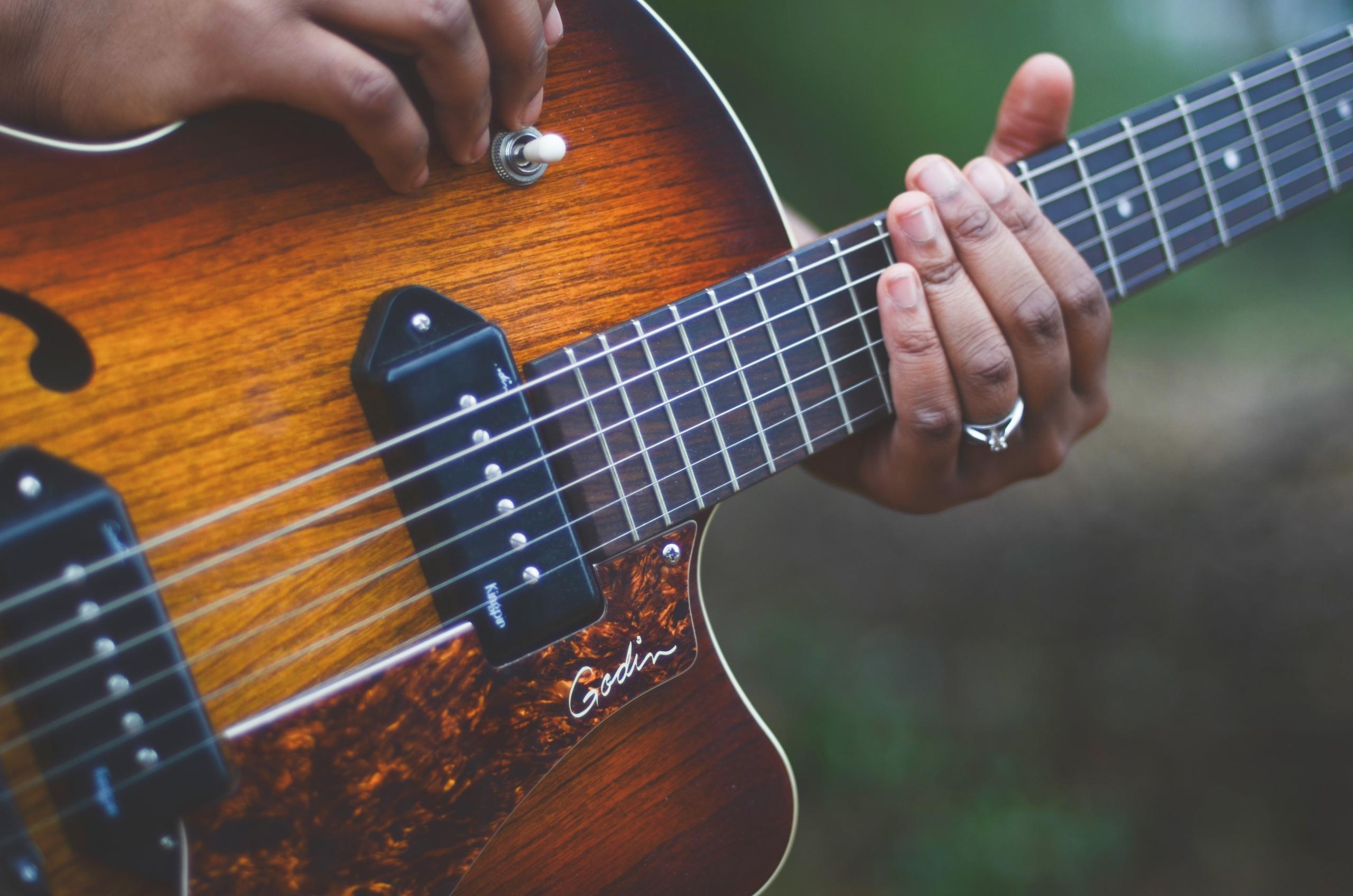 Person Holding Brown and Black Guitar