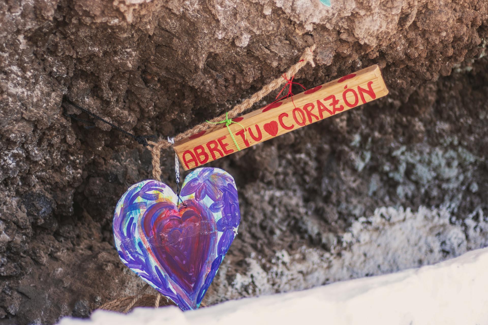 a heart charm that says "abre tu corazon" which means "open your heart."