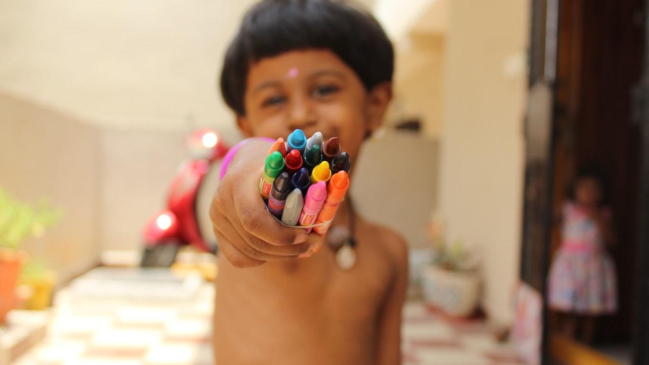 Kids enjoy colouring books with crayons.
