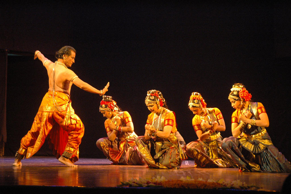 one male dancer with four female dancers on stage