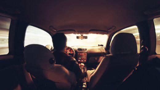 Rear view of a man driving a car