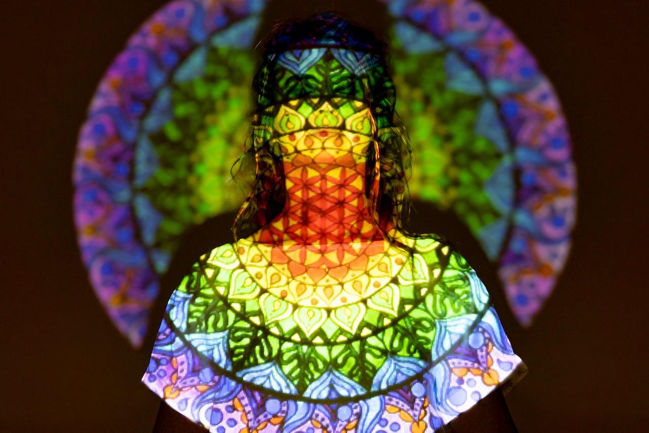 A person with a projection of a mandala on them