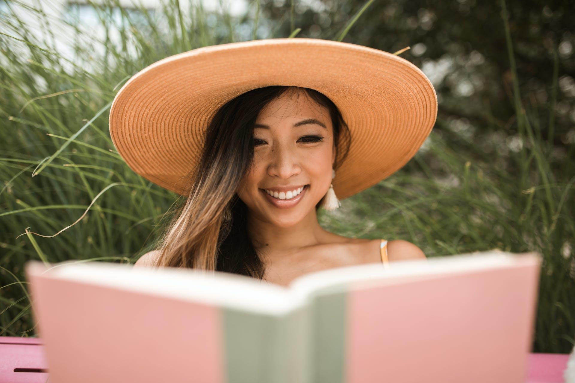 A girl smiling while reading a book