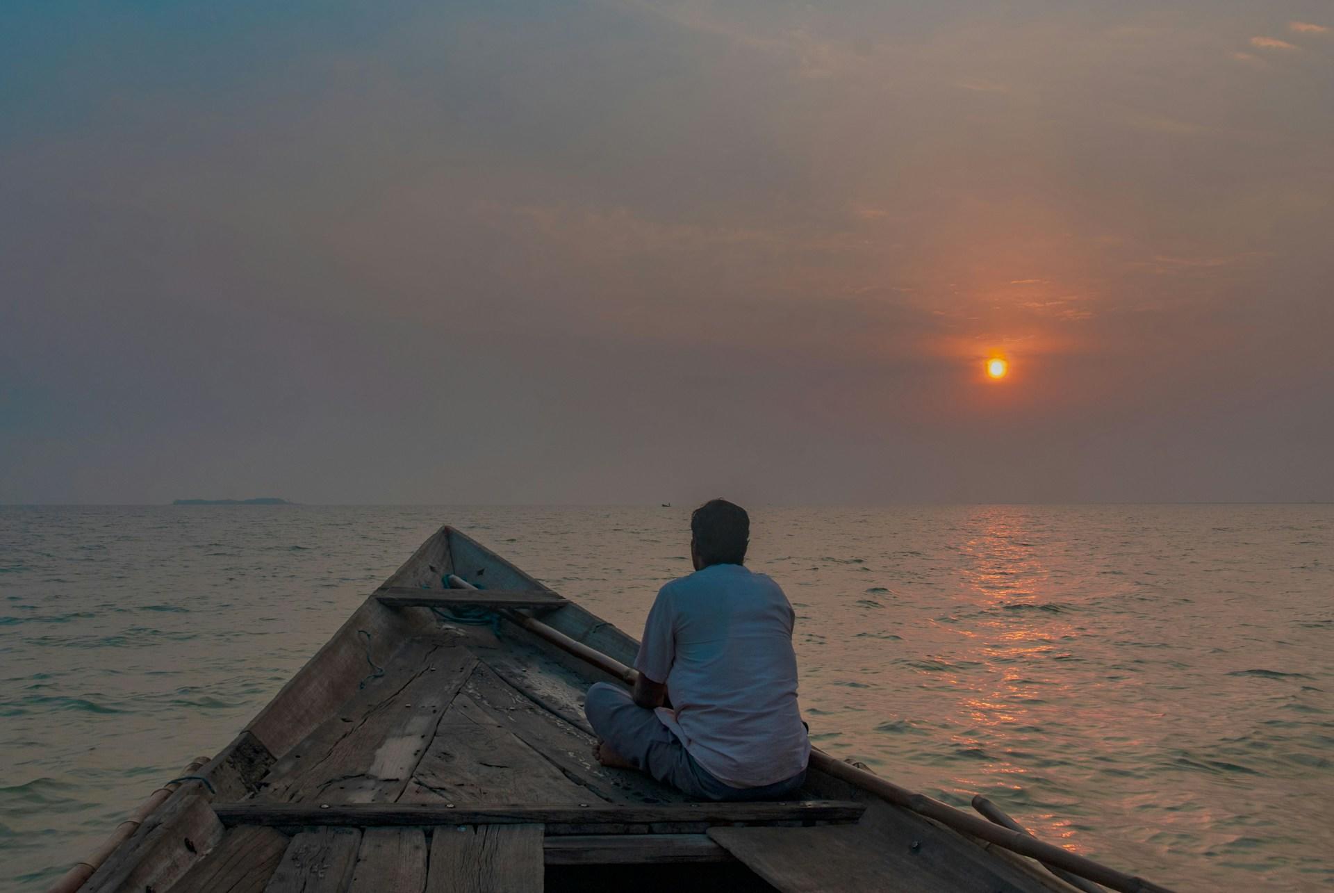 A view of the sunset on Chilika Lake from a wooden boat on the water