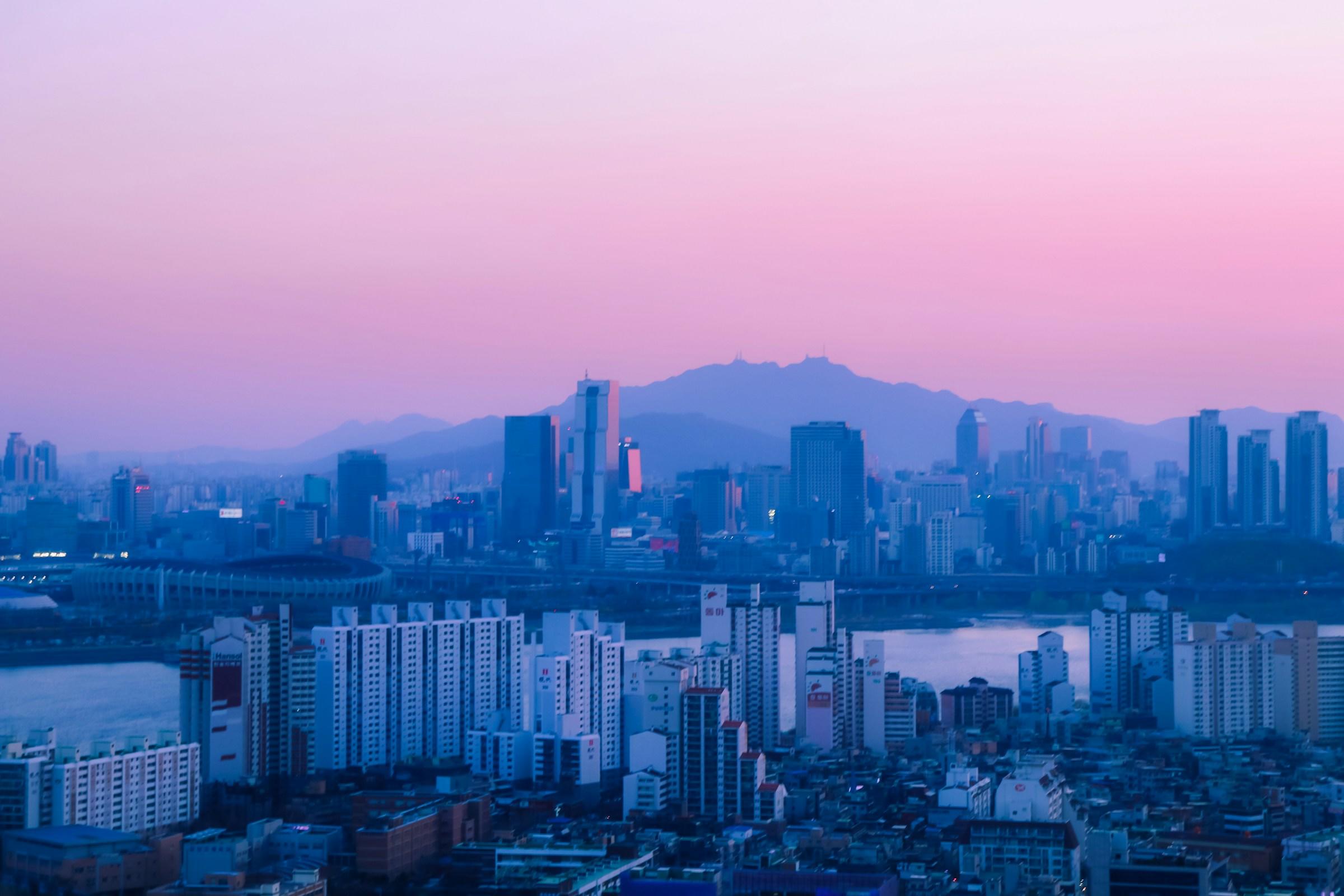 Pink sky and blue city skyline at sunrise in Seoul