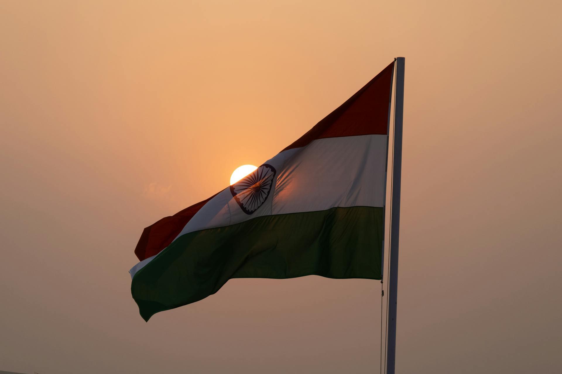 An Indian flag waving against a sunset sky