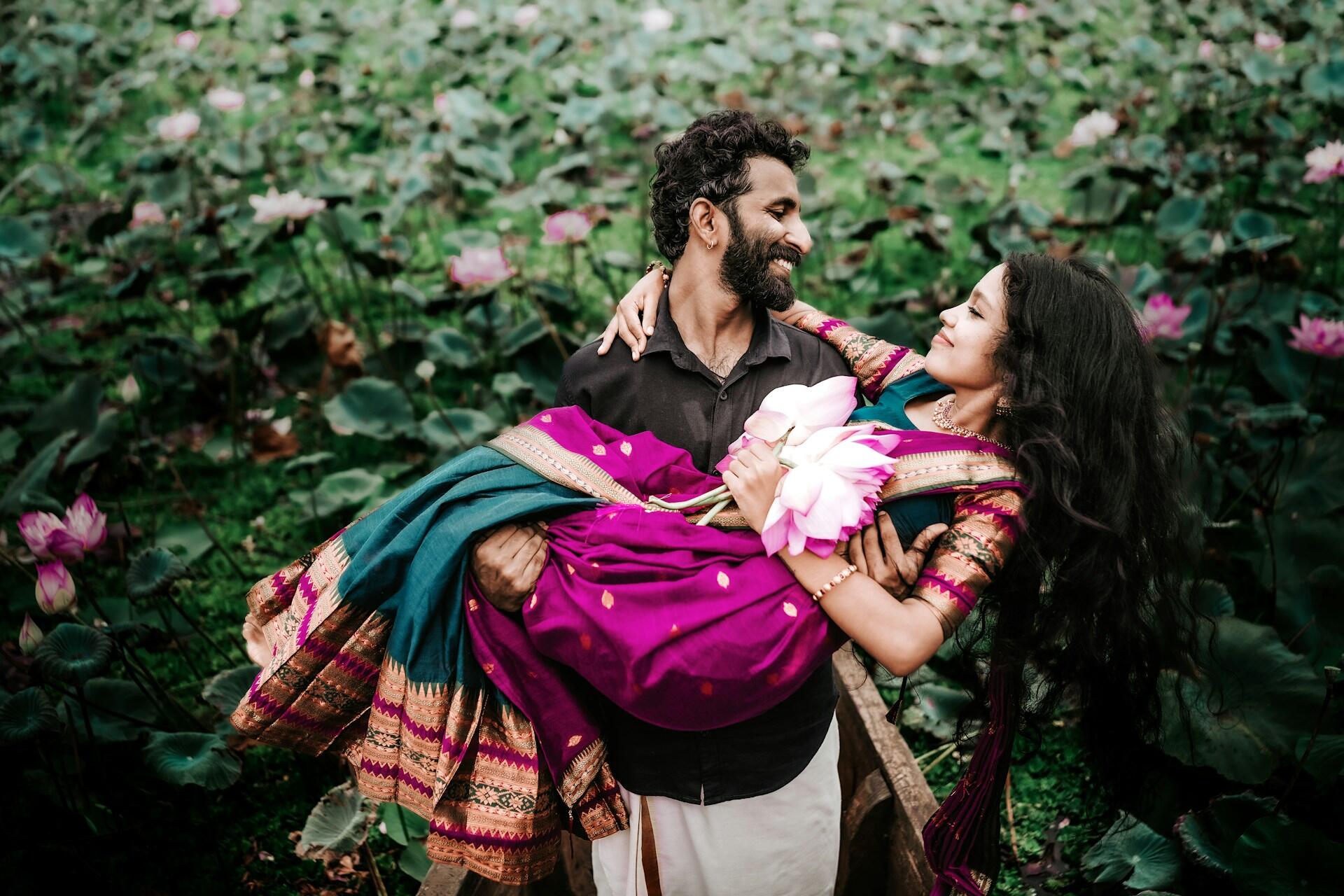 a man carrying his fiancee in his arms