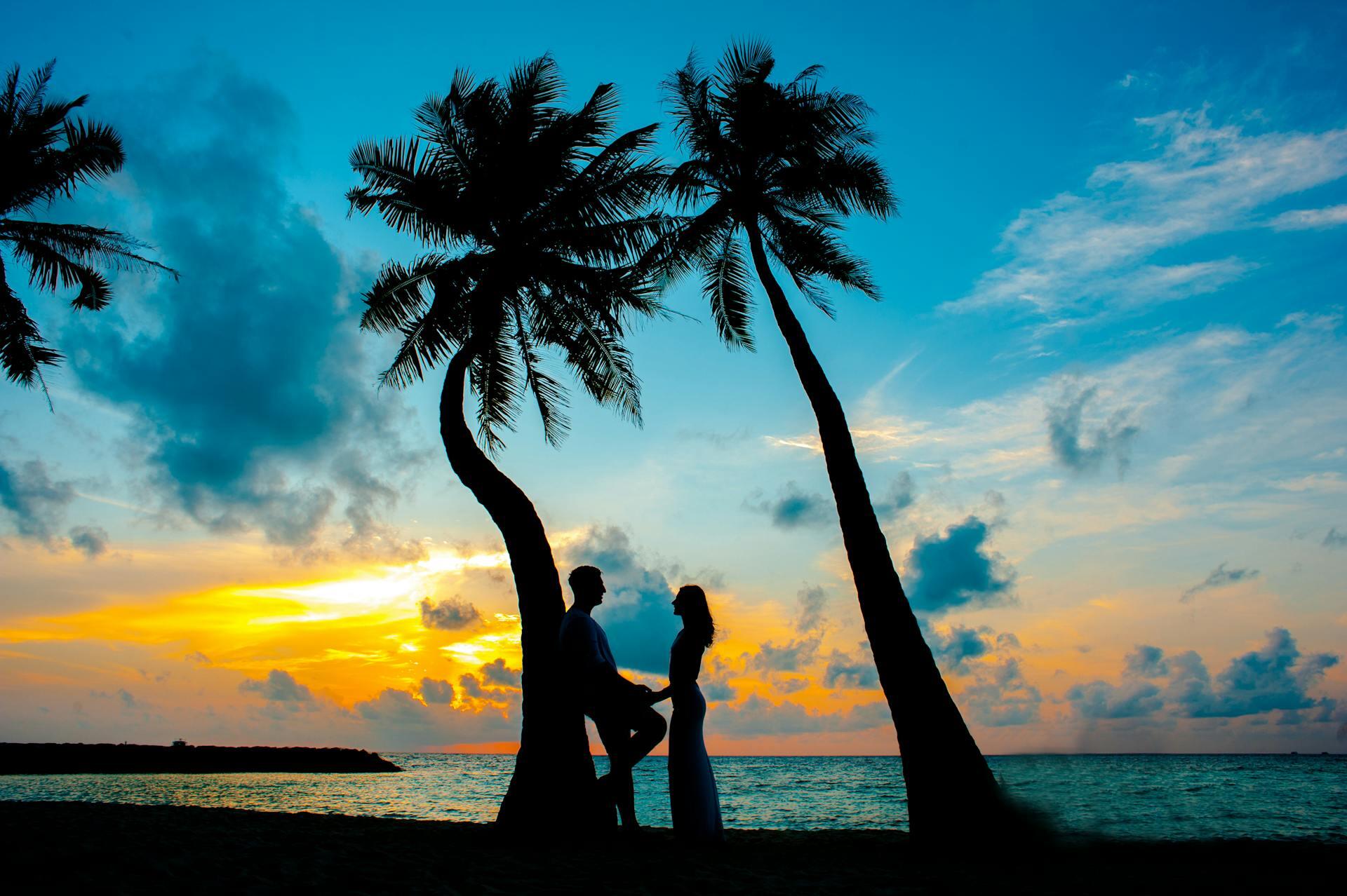 a couple on a tropical beach at sunset