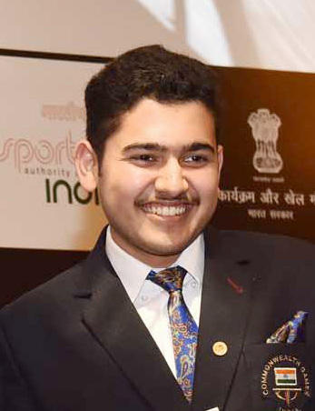 Anish Bhanwala smiling and wearing a suit