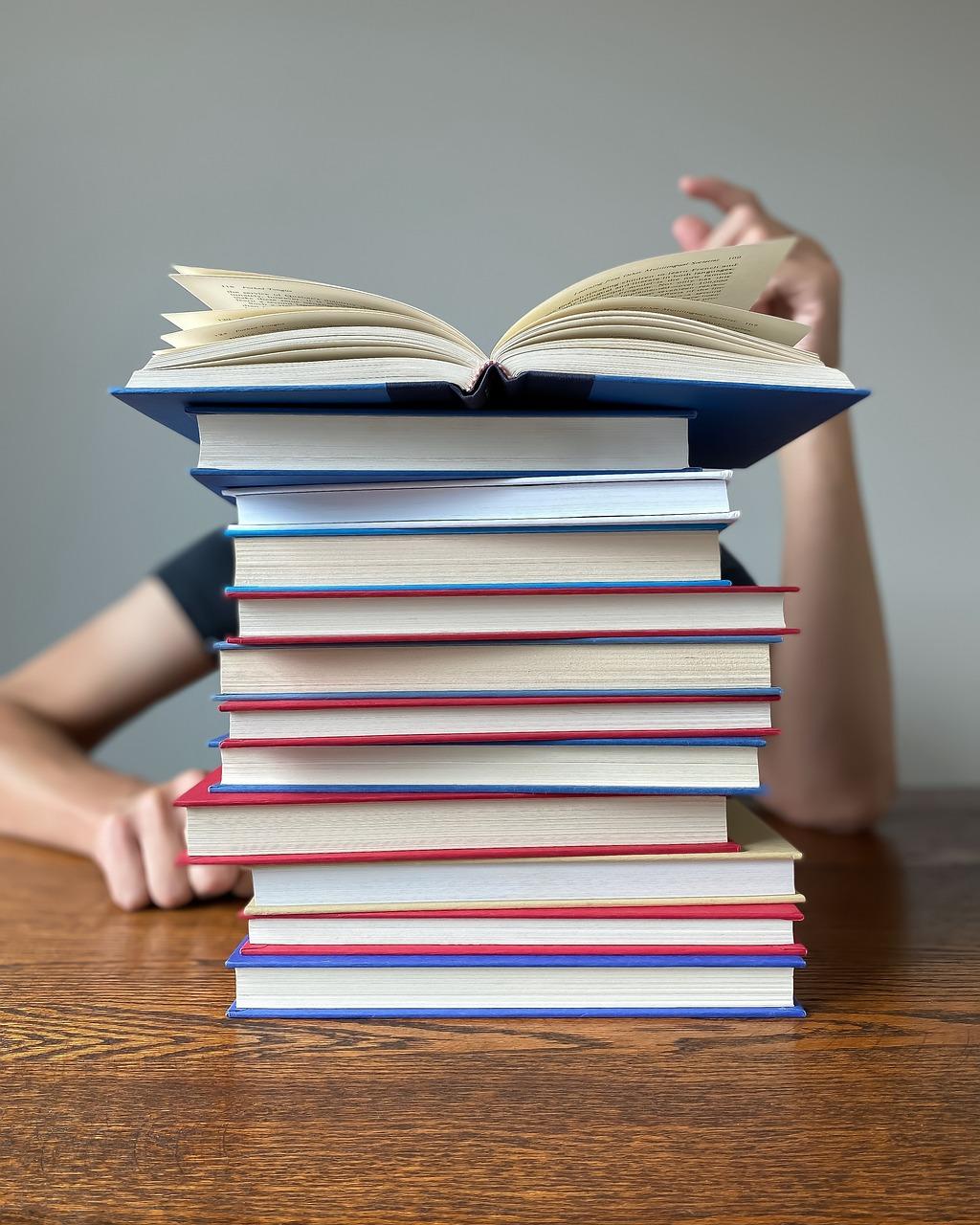 pile of books in front of a person