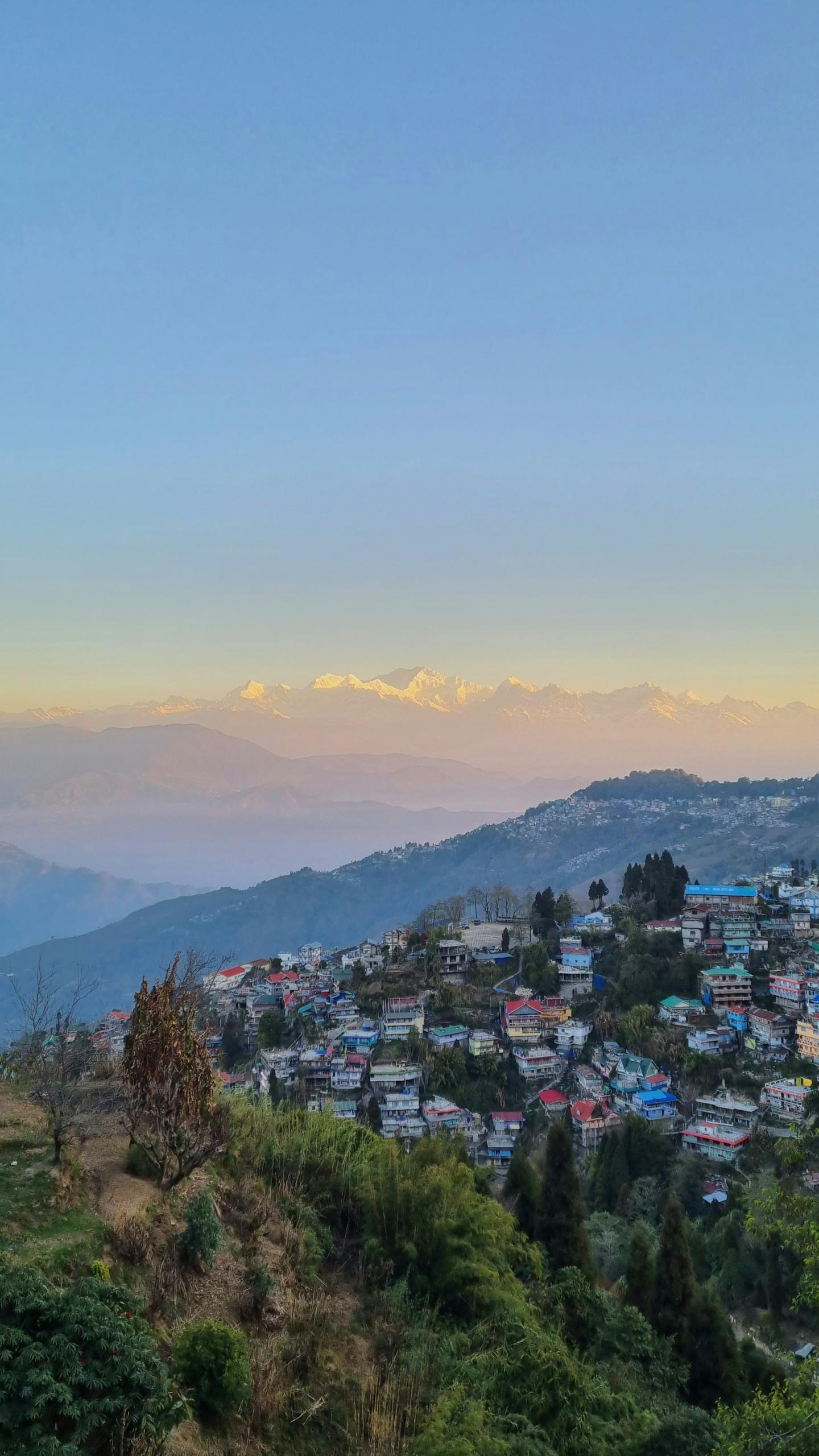Distance shot of Darjeeling in the foothills of the Himalayas with mountains in the background.