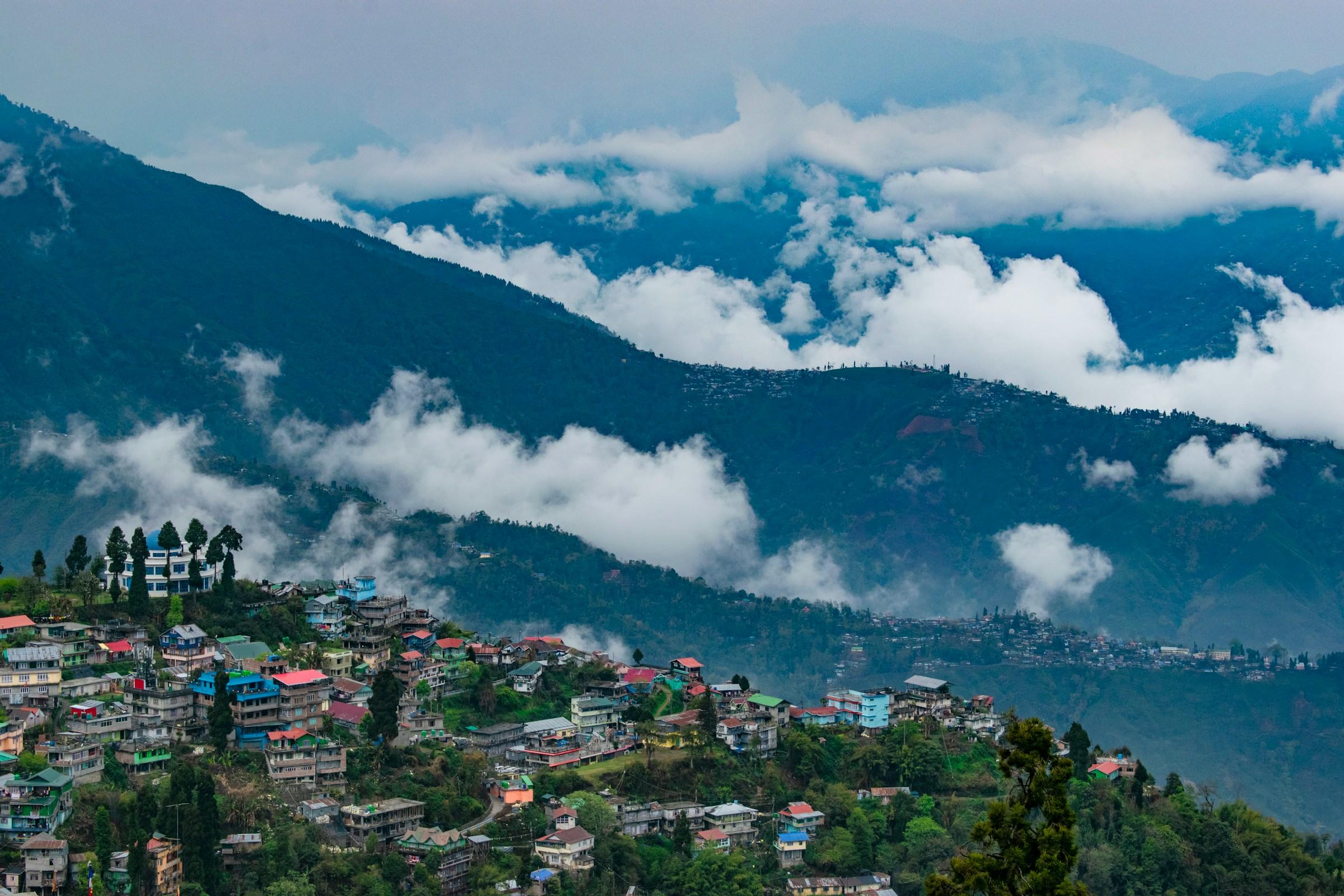 An aerial shot of Darjeeling showing clouds in the distant hills
