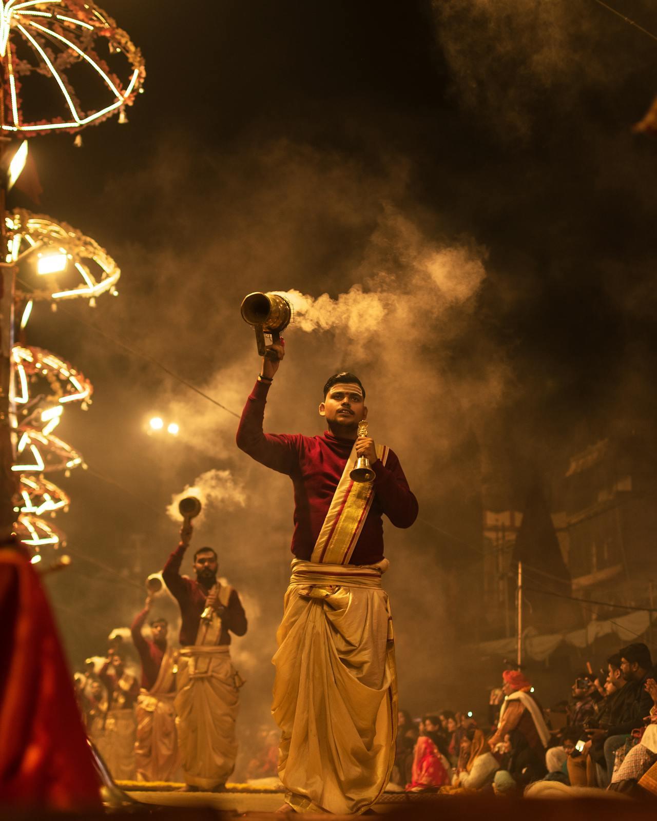 Pundits performing Ganga Aarti ritual, holding incense.
