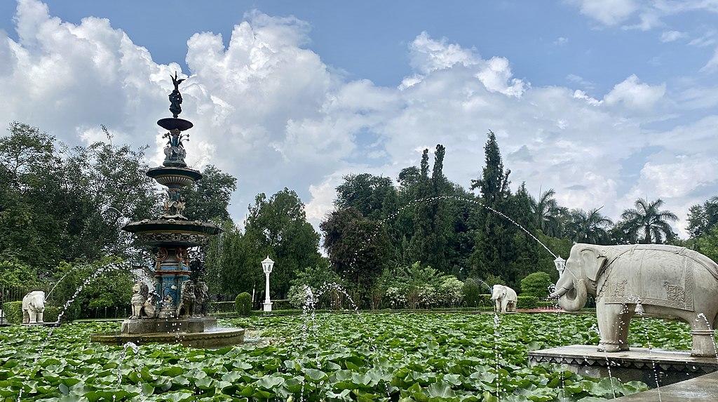 A large fountain with lilypads growing in the centre with elephant statues shooting water toward the middle