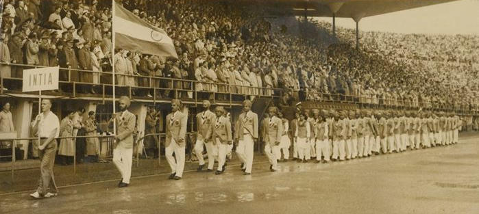 A sepia toned photo of the Indian Olympic participants marching at the opening ceremony in Helsinki 1952
