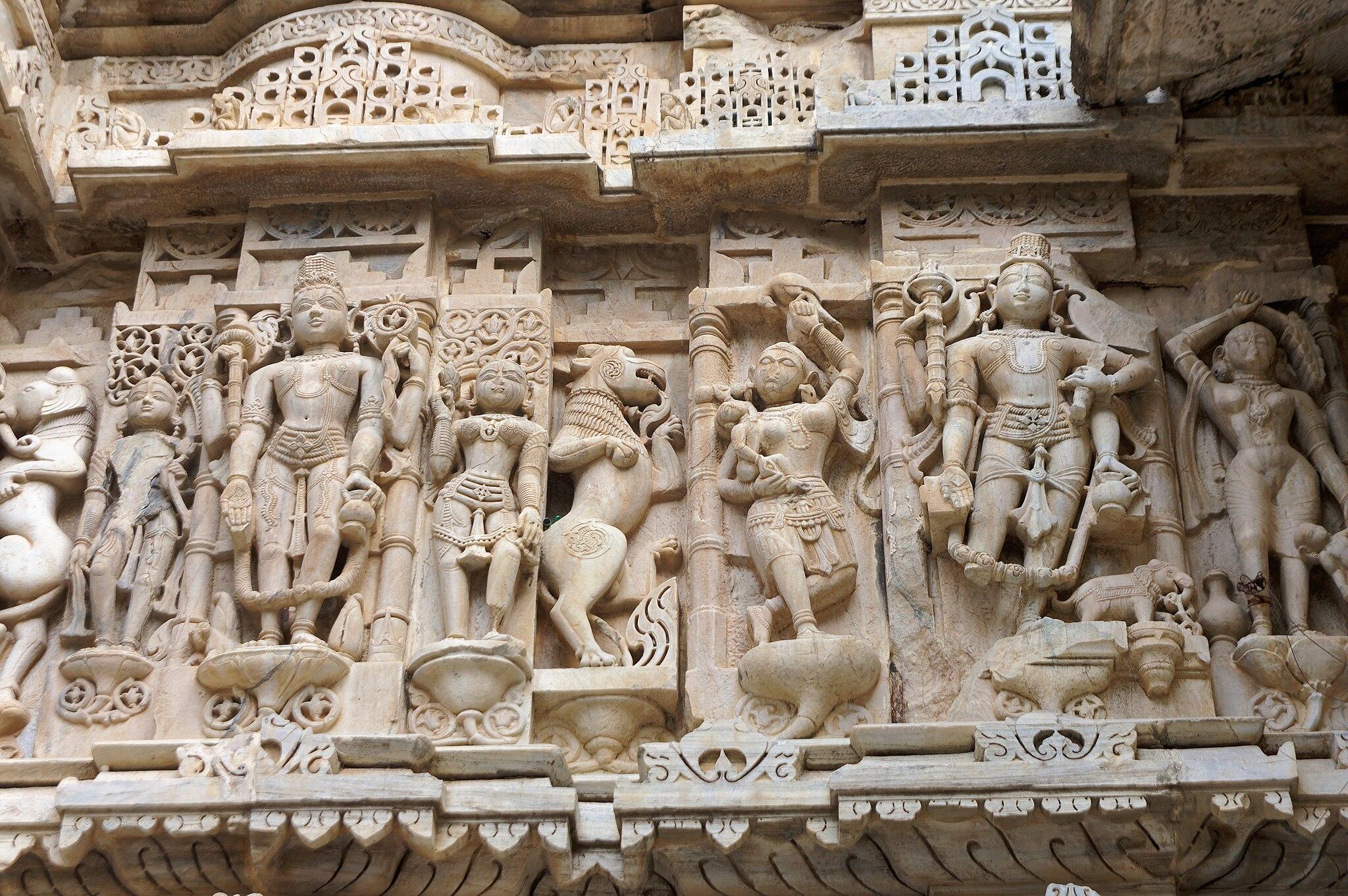A close up of images of people and lions carved into the marble of the Jagdish Temple