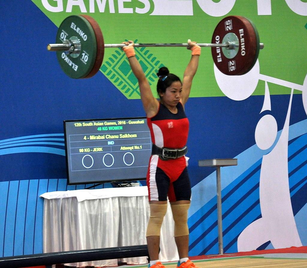 Mirabel Chanu mid-lift, holding a barbell above her head