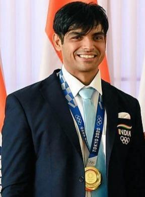 Neeraj Chopra wearing an Olympic gold medal around his neck.
