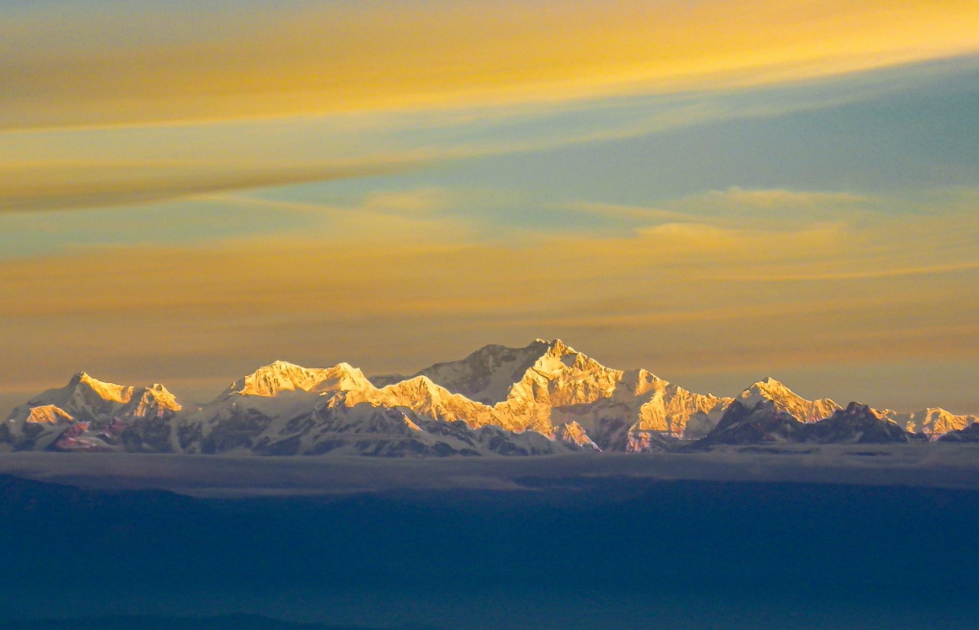 A beautiful view of Mount Kanchenjunga as seen from Tiger Hill. The sun is shining on the peaks making the mountain appear golden.