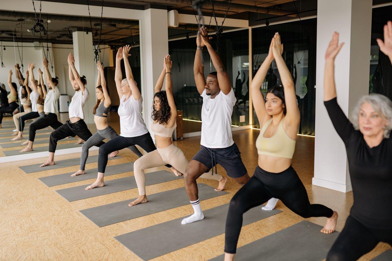 A group of yoga students practicing virbhadrasana I together.