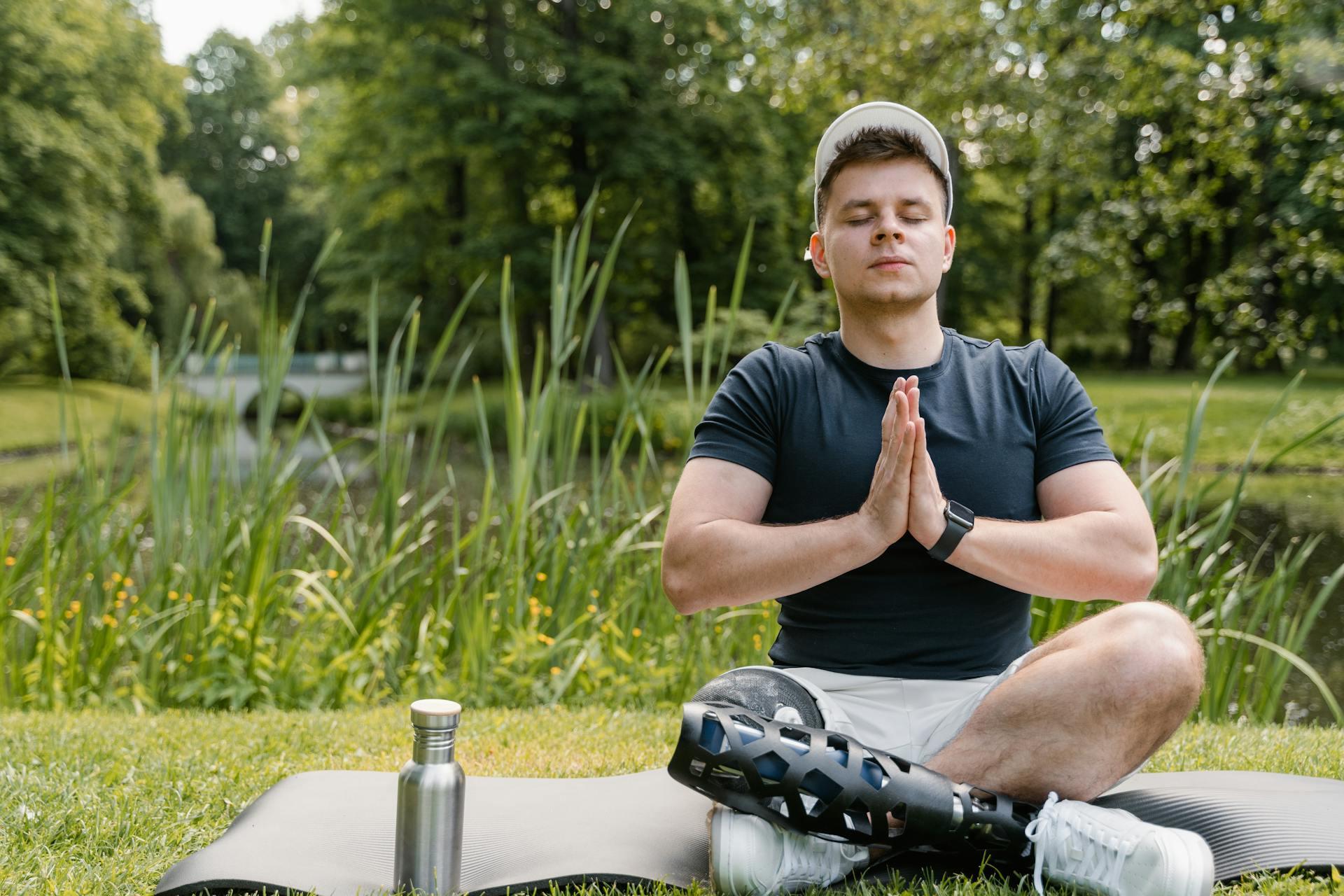 A man with a prosthetic leg meditation on a yoga mat