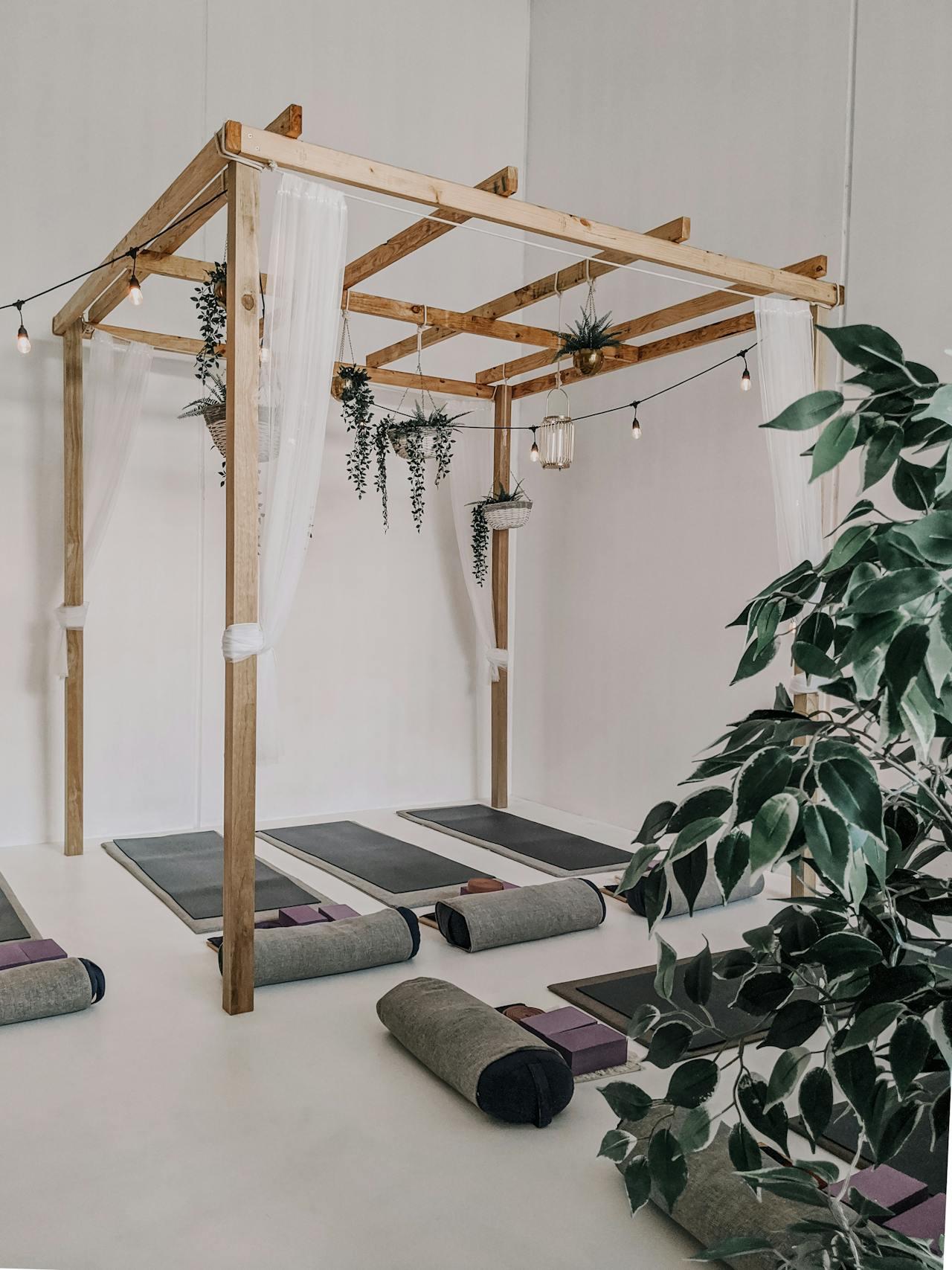 A yoga studio nicely decorated with lights and yoga mats with pillows