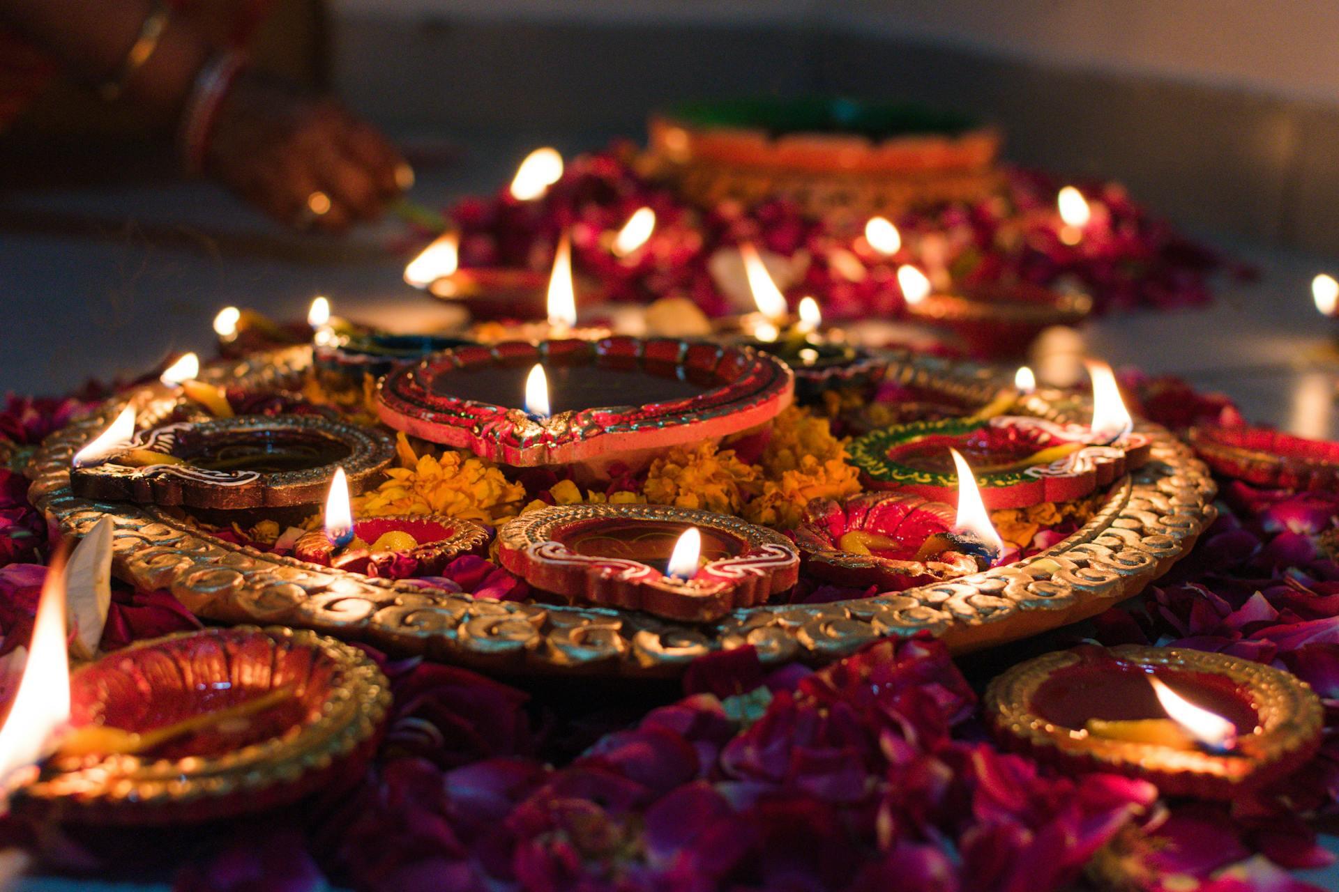 Diwali diyas lit with flowers surrounding 