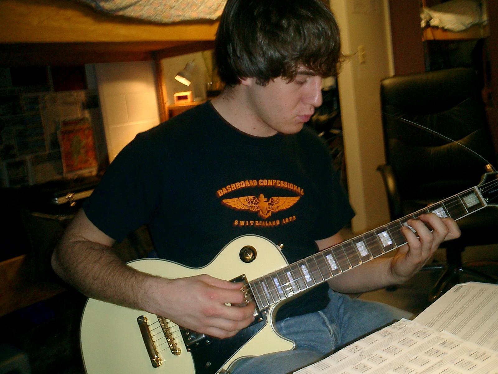 A man practising the guitar.