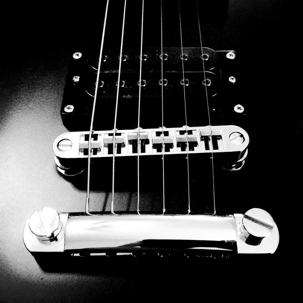 The bridge and body of the guitar.