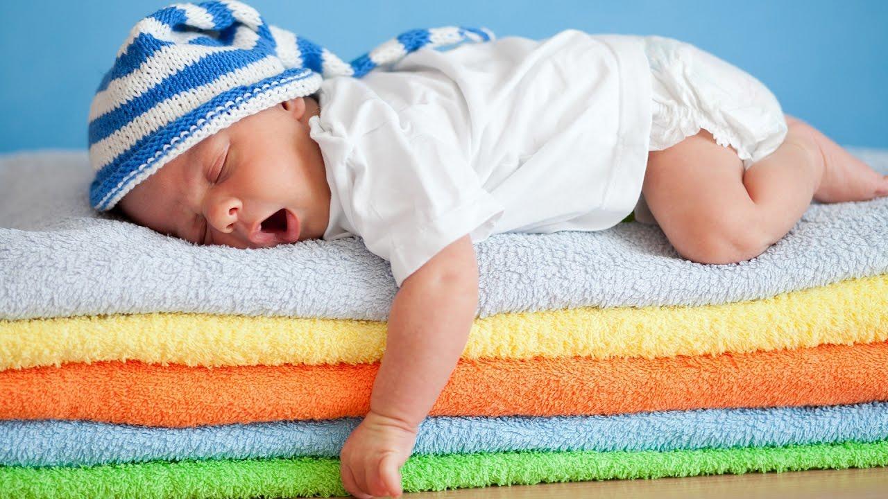 A baby asleep on a pile of towels.