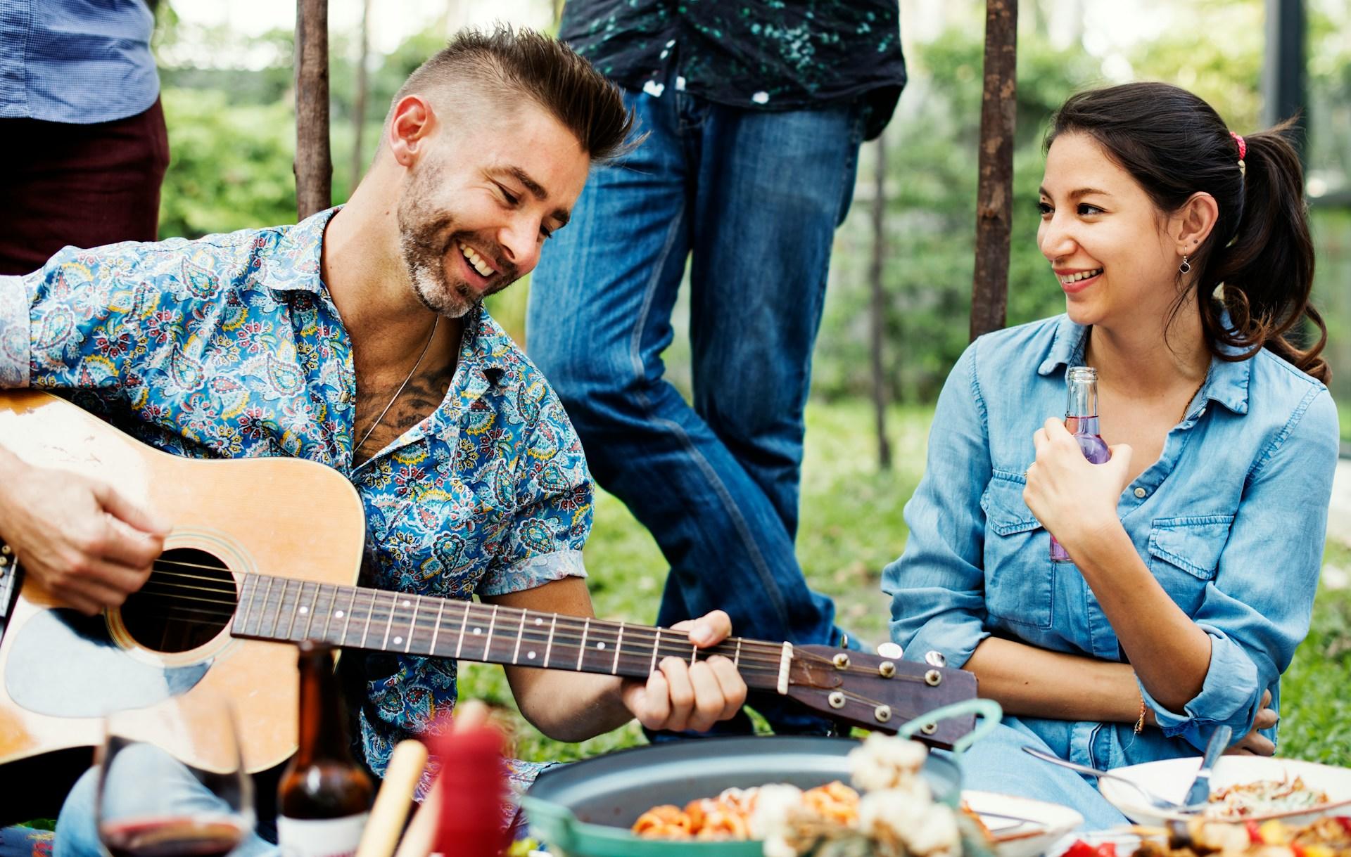 Ragazzo suona la chitarra a un picnic