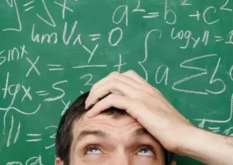Ragazzo di fronte a lavagna con formule matematiche
