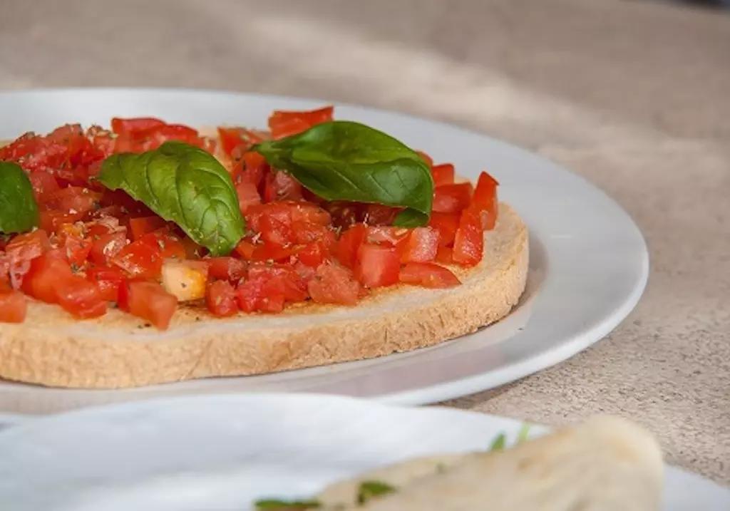 La bruschetta consiste in una fetta di pane raffermo o arrostito sulla griglia o in forno, su cui viene strofinato a caldo uno spicchio d'aglio, il quale per il calore si fonderà col pane