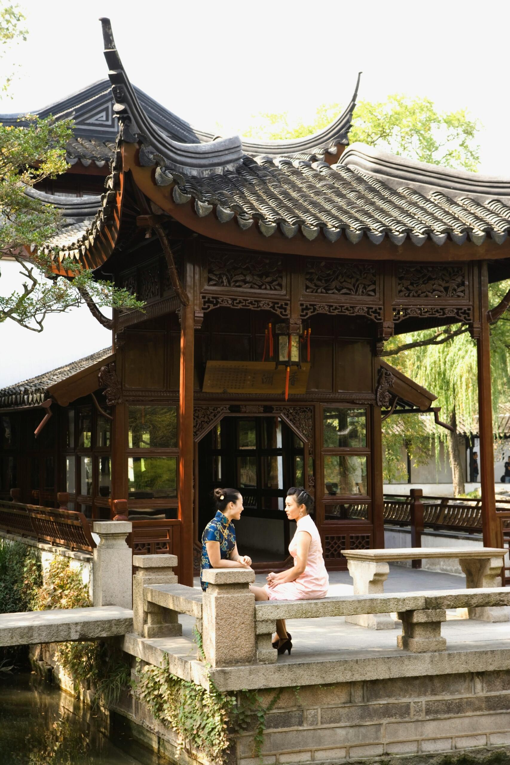 Due ragazze in abiti tradizionali chiacchierano davanti a un tempio.