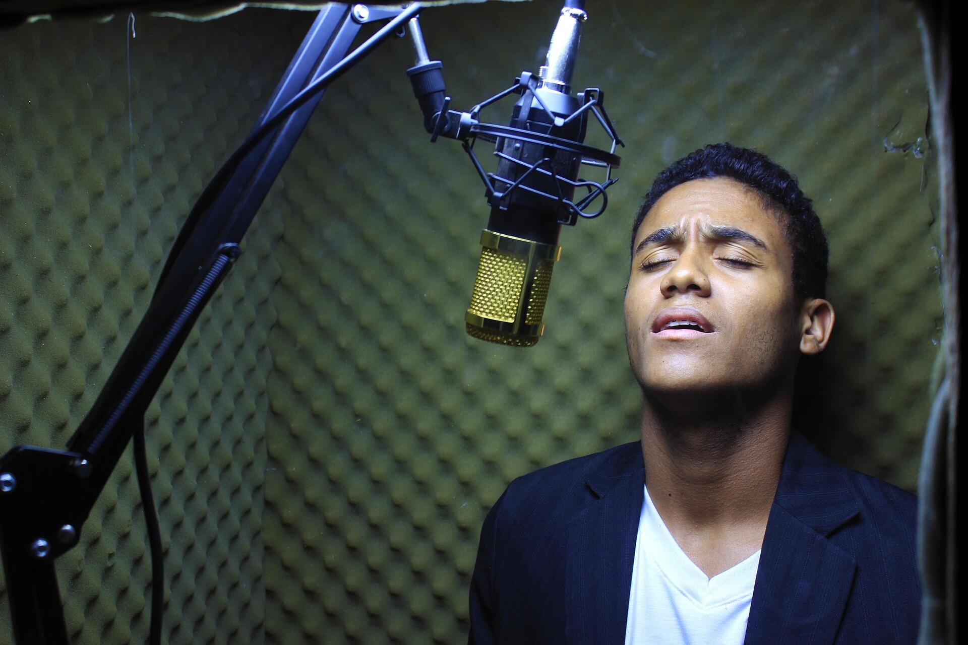 Un ragazzo si esercita a cantare in uno studio artigianale.