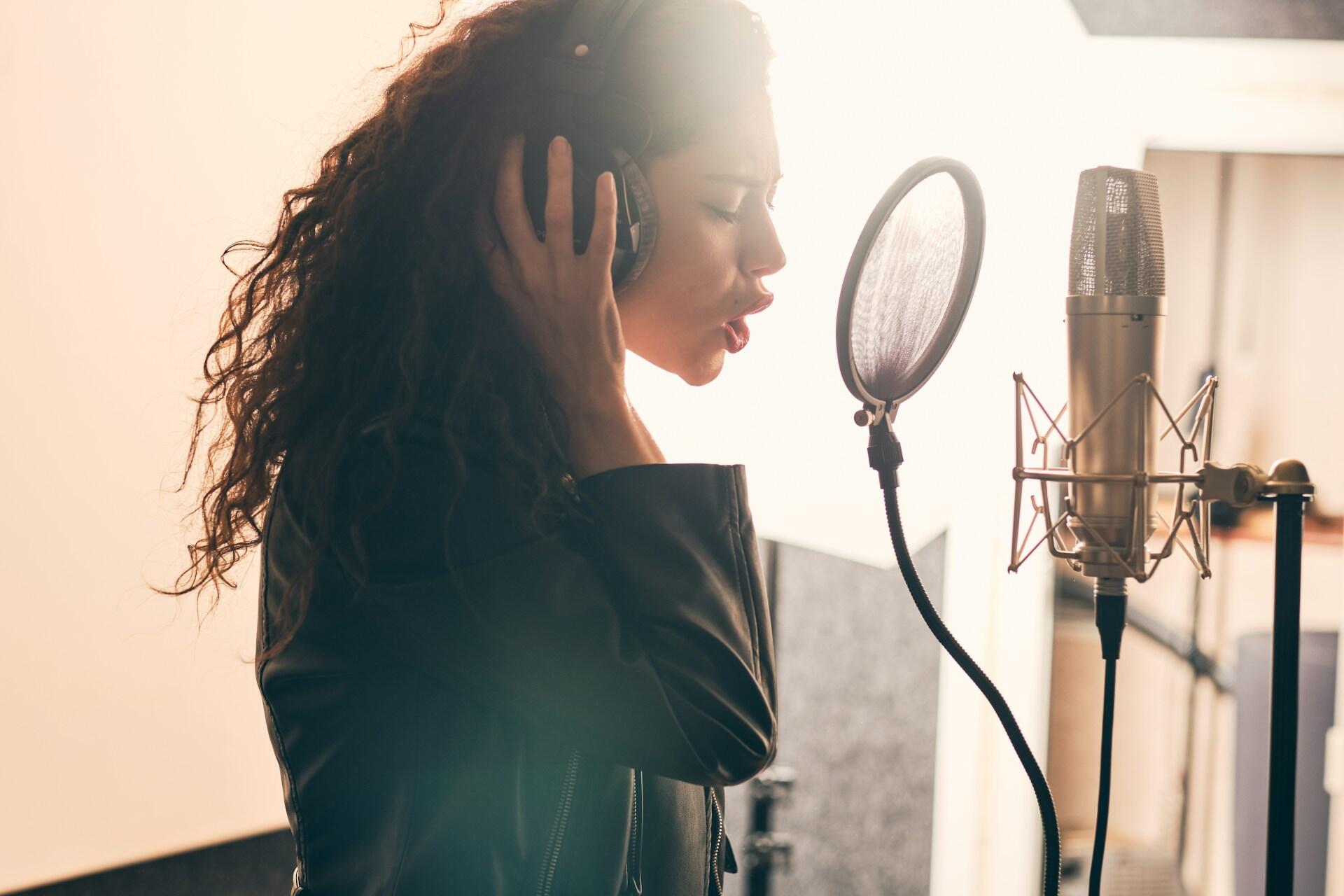 Una ragazza registra un canzone in studio.