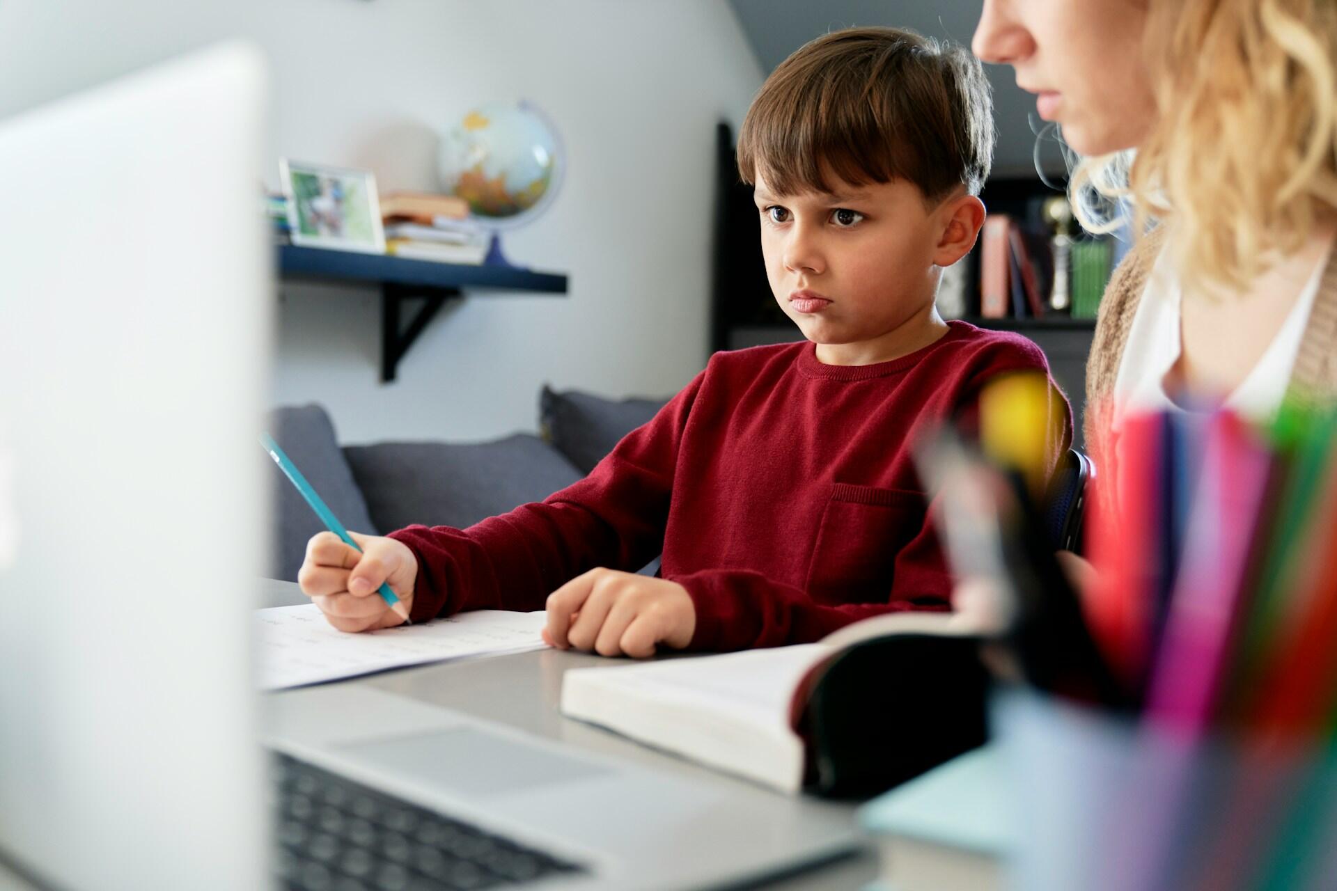 Studente che guarda il computer insieme alla mamma