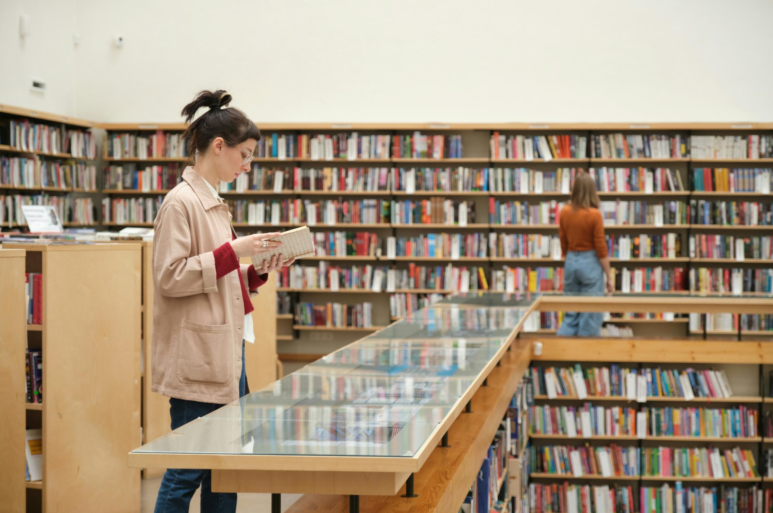 Ragazza sfoglia un libro in biblioteca.