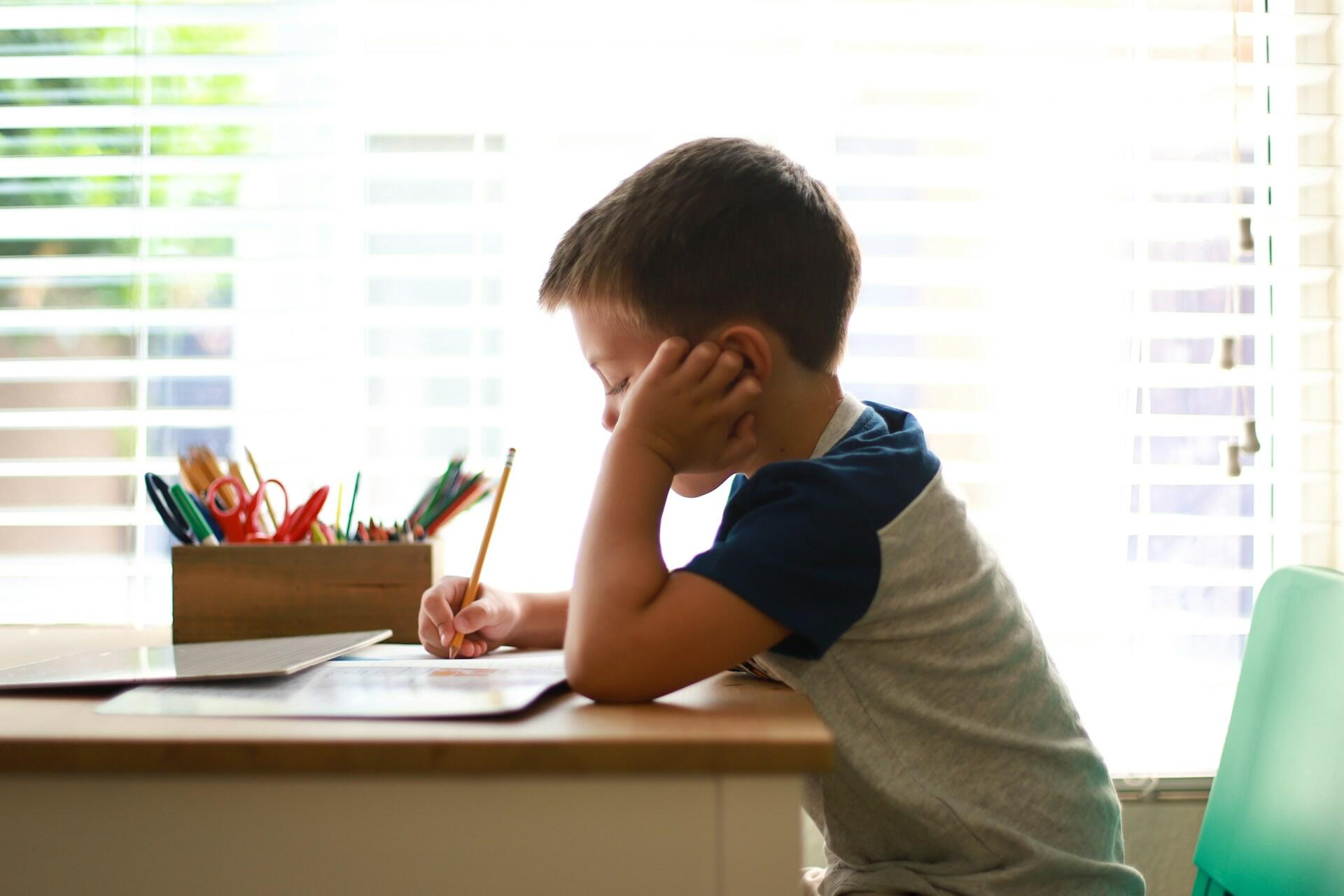 Bambino autistico a scuola fa i compiti.
